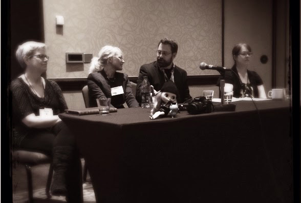 Stephanie sits at the end of a table during a panel presentation at the 2014 Southwest Popular Culture/American Culture Conference