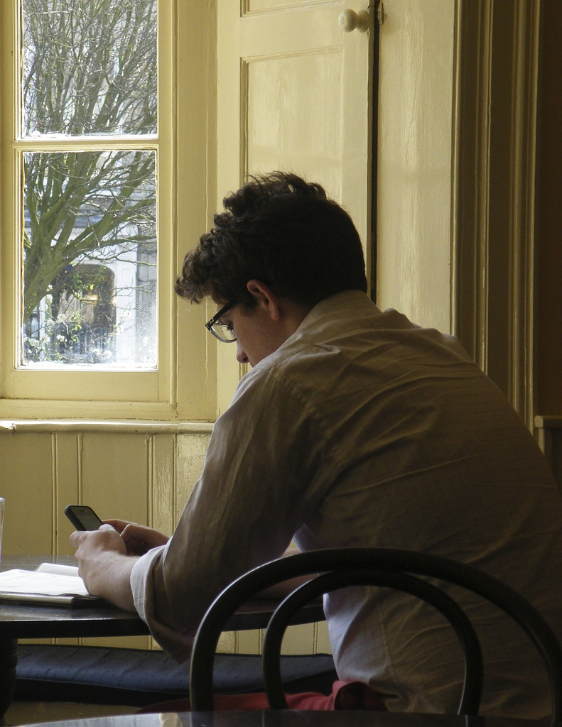 man at table with cell phone