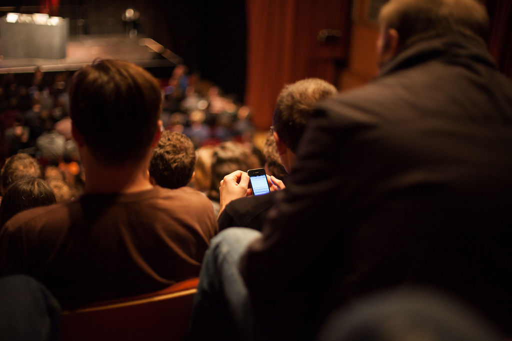Phone being used in a crowded auditorium