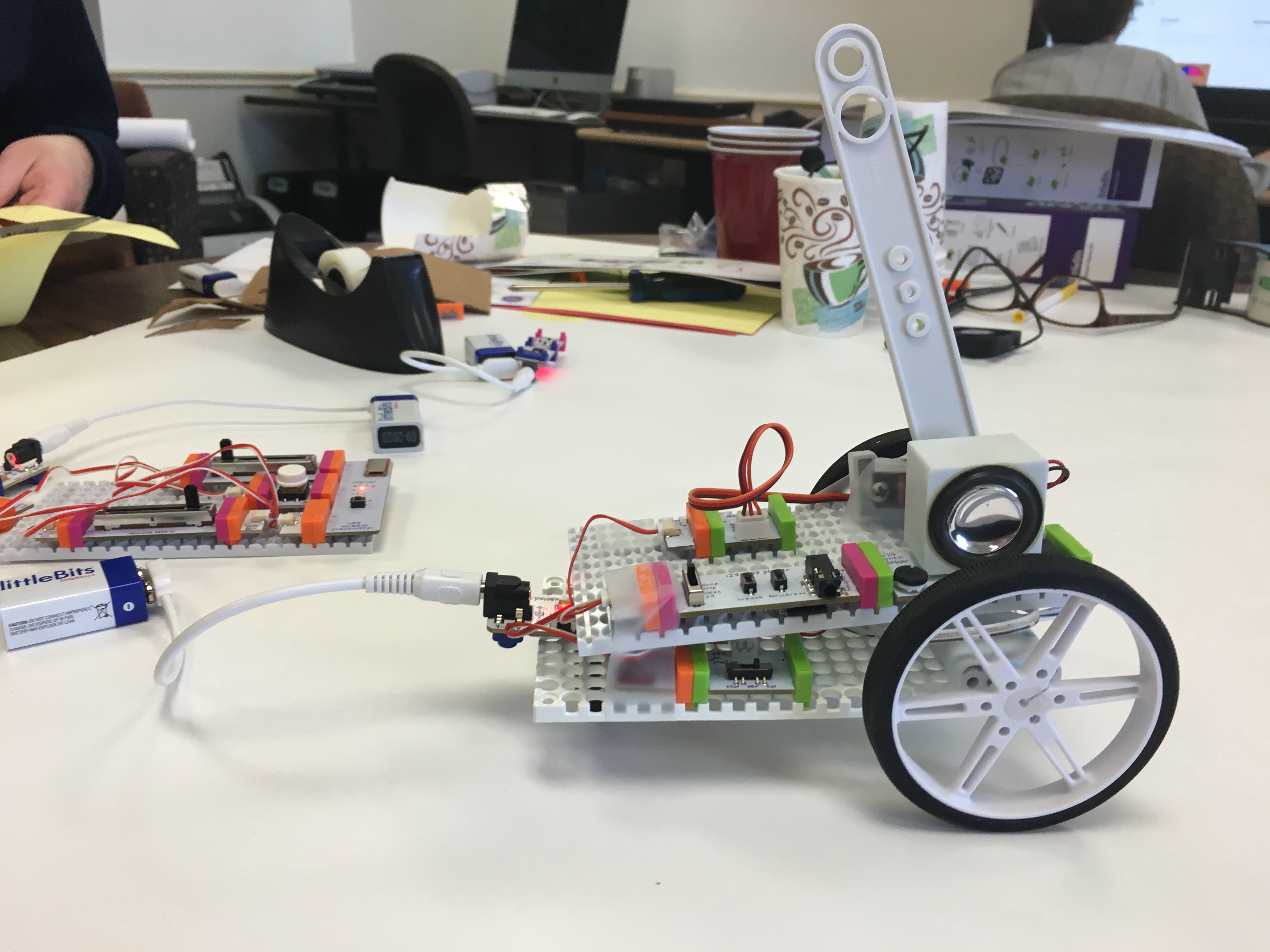 the skeleton of the chicken constructed out of littleBits: an assemblage sits on two wheels and has a lever sticking up from the top