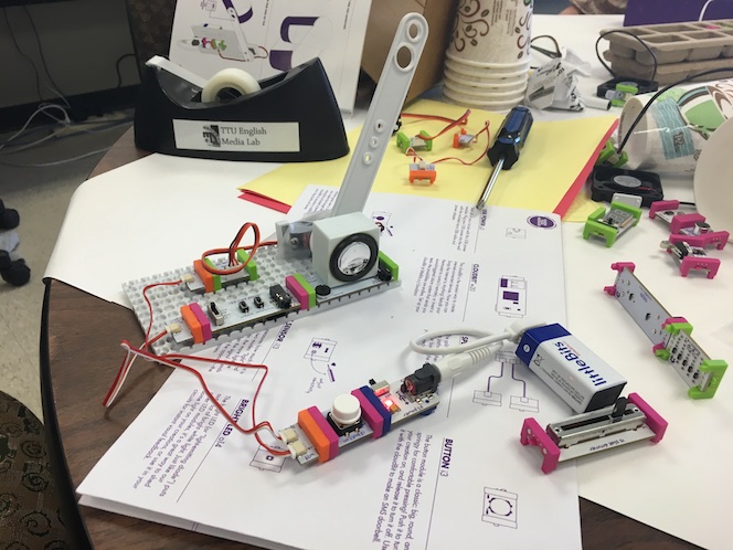 a collection of littleBits on a table, some attached to a base component and others attached by a series of wires