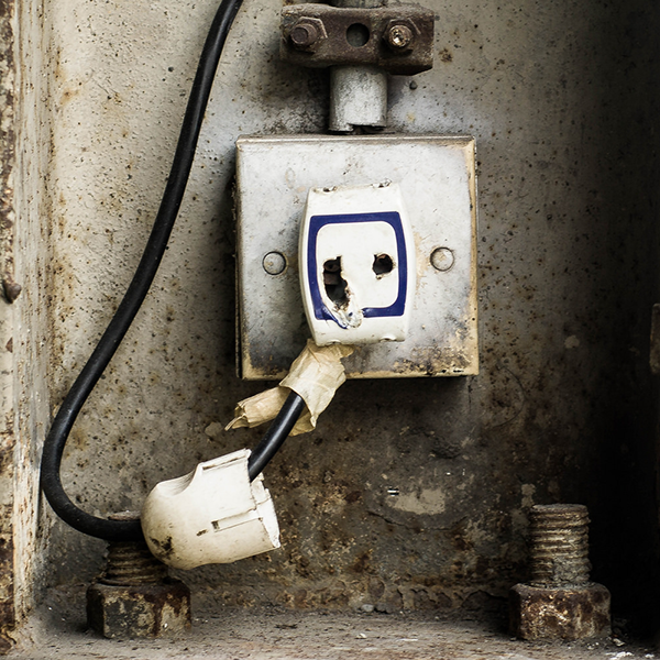 An
              image depicts a rusty, worn out, dysfunctional electrical
              outlet.