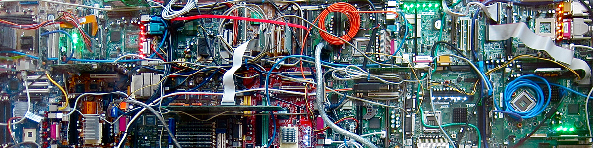An close up image
              of a hard-drive; multiple wires--red, white, silver,
              off-white, blue, and teal--flow across the circuit board.