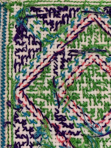 The reverse side of a geometric cross-stitch pattern in a modified Hmong style