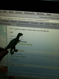 Photo of a computer screen showing an email to a department administrator, with a sparkle dino held in front.