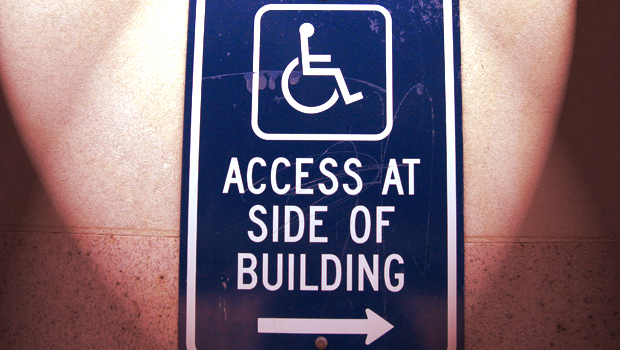 A blue sign that reads ACCESS AT SIDE OF BUILDING