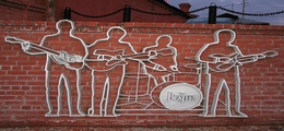 outline of the Beatles rock band on brick wall