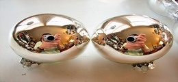 two reflective spheres with the image of a man taking a photo in them