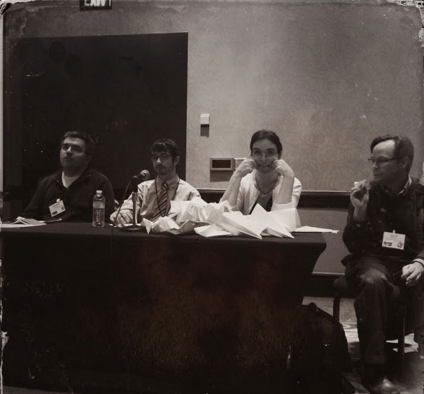 Jennifer deWinter sits at the end of a table during a panel presentation at the 2014 Southwest Popular Culture/American Culture Conference