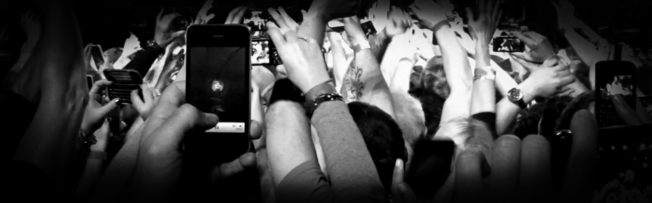 black and white photograph of a fan taking a photo on his iPhone of Bruce Springsteen at the April 4, 2012 concert at the Izod Center.