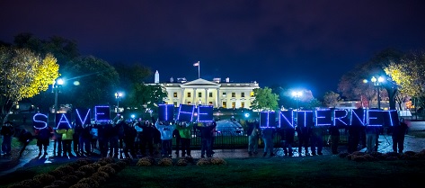 Activist demonstration before The White House lawn at night with Free the Internet in neon lights
