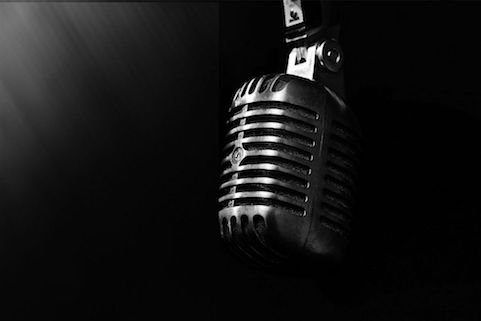 an old fashioned microphone in black and white with a dark background