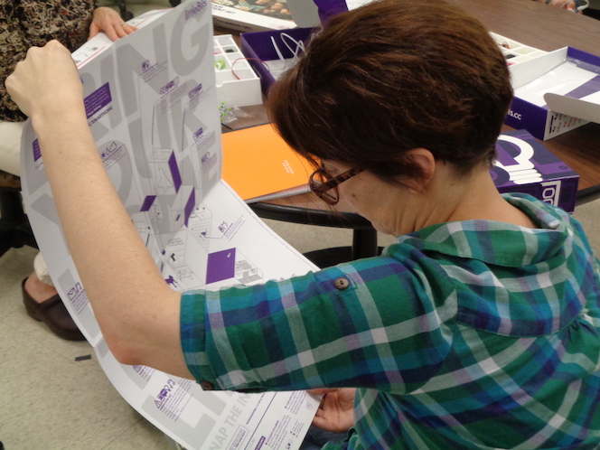 Jamie holds up some print instructions for littleBits and studies them