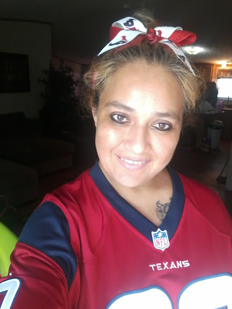 Image of a smiling woman wearing a Texans football jersey and a colorful bow.