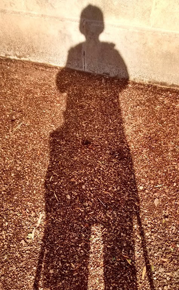 A full-body shot showing a person's shadow.