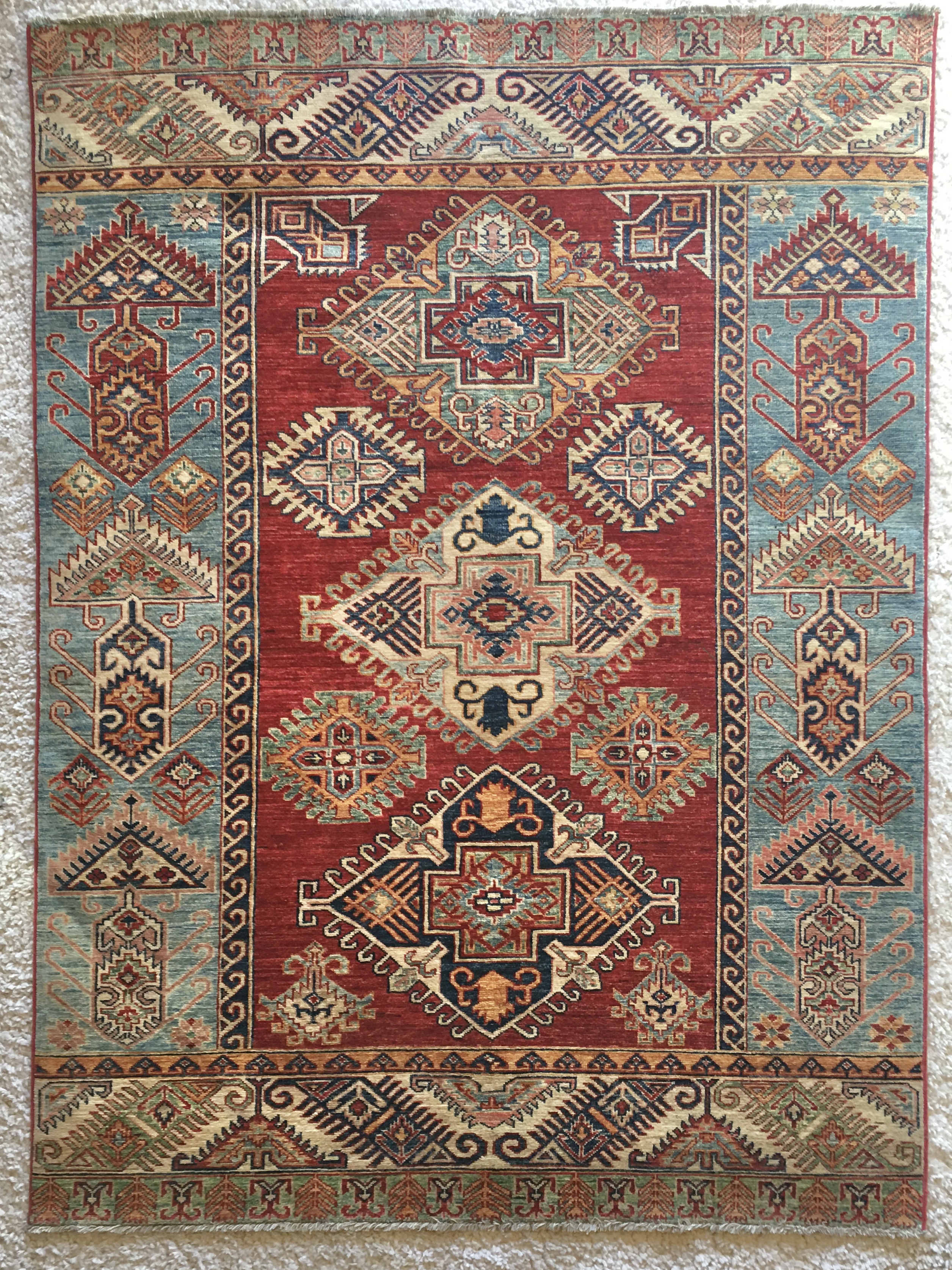 a bright blue, gold, and red geometric rug