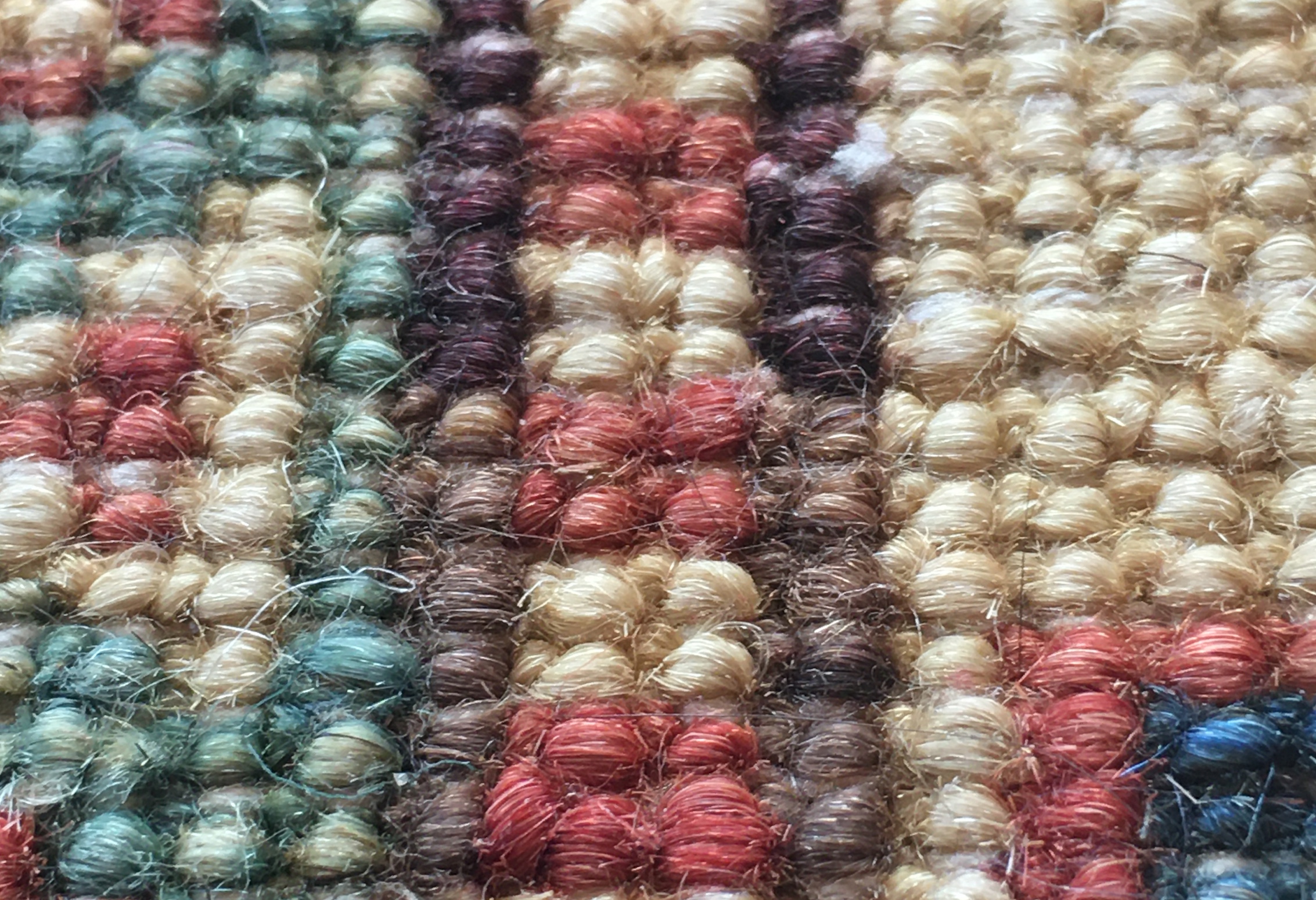 Detailed photo of rug knots from the back side showing a change in yarn color