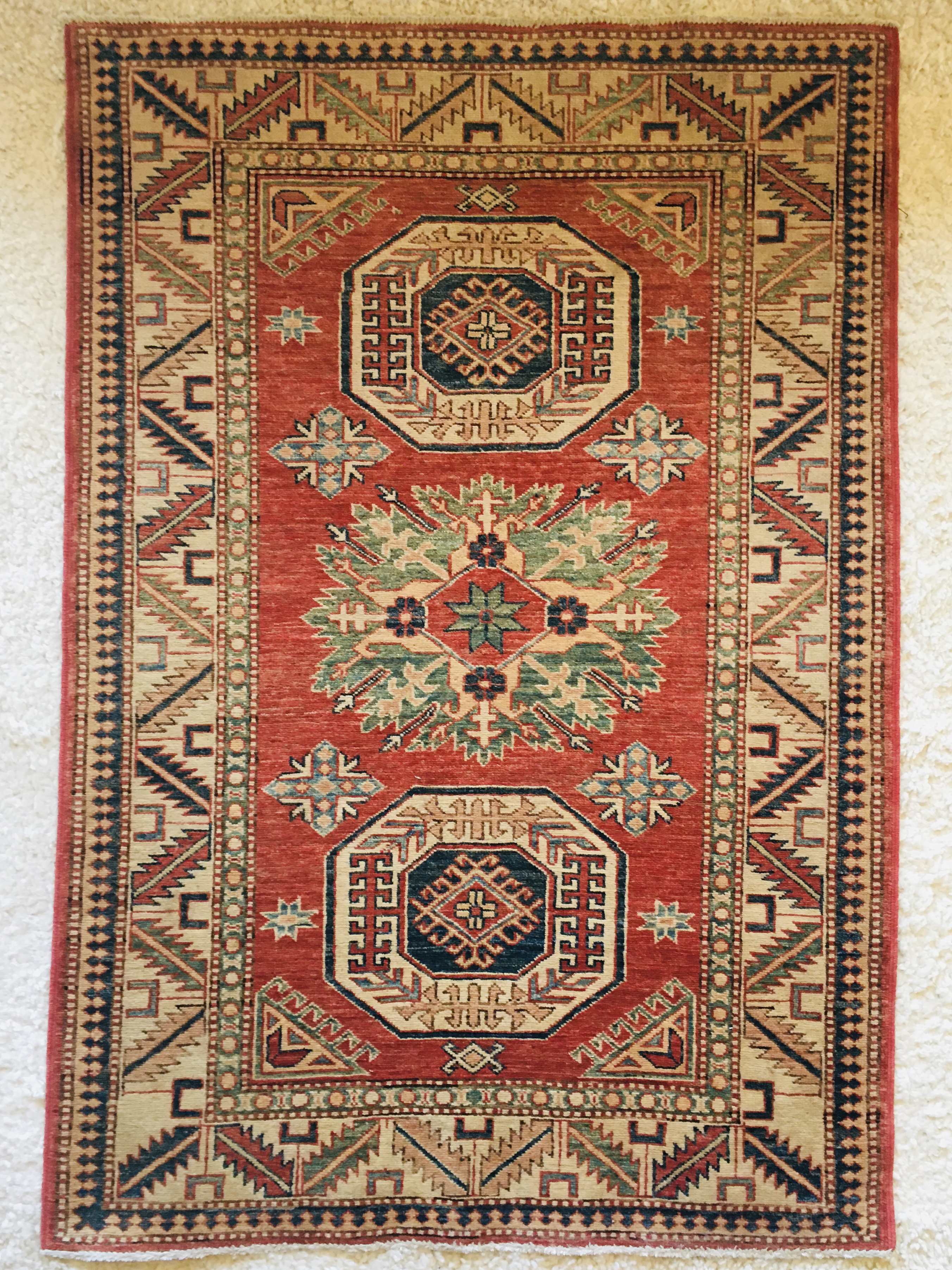 An orange and white rug with geometric and floral designs