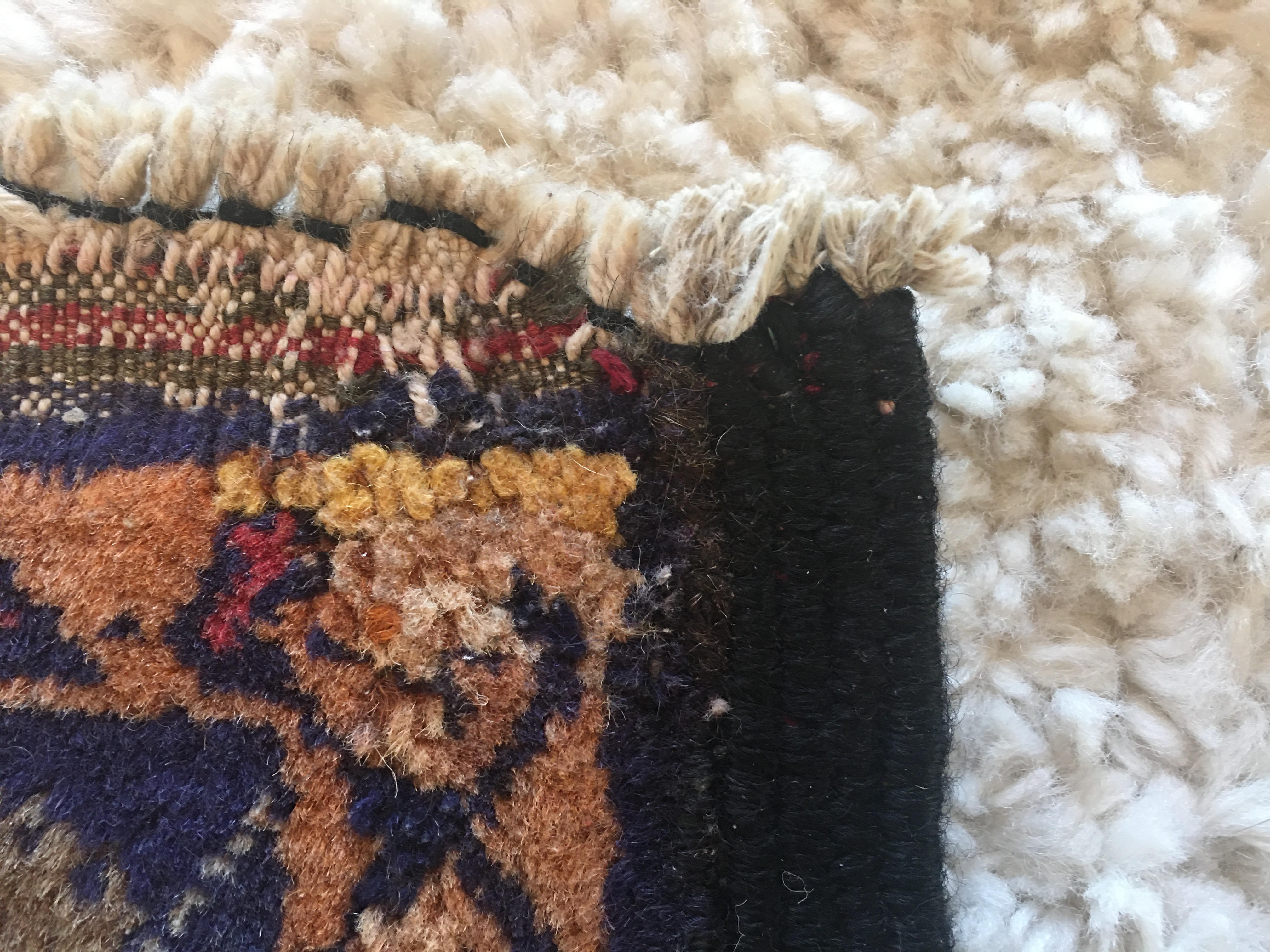 A close-up of the upper right corner of the Shirin rug. Damage to the weaving, most likely from being hung on a yurt wall, has been bound off so the corner is no longer square