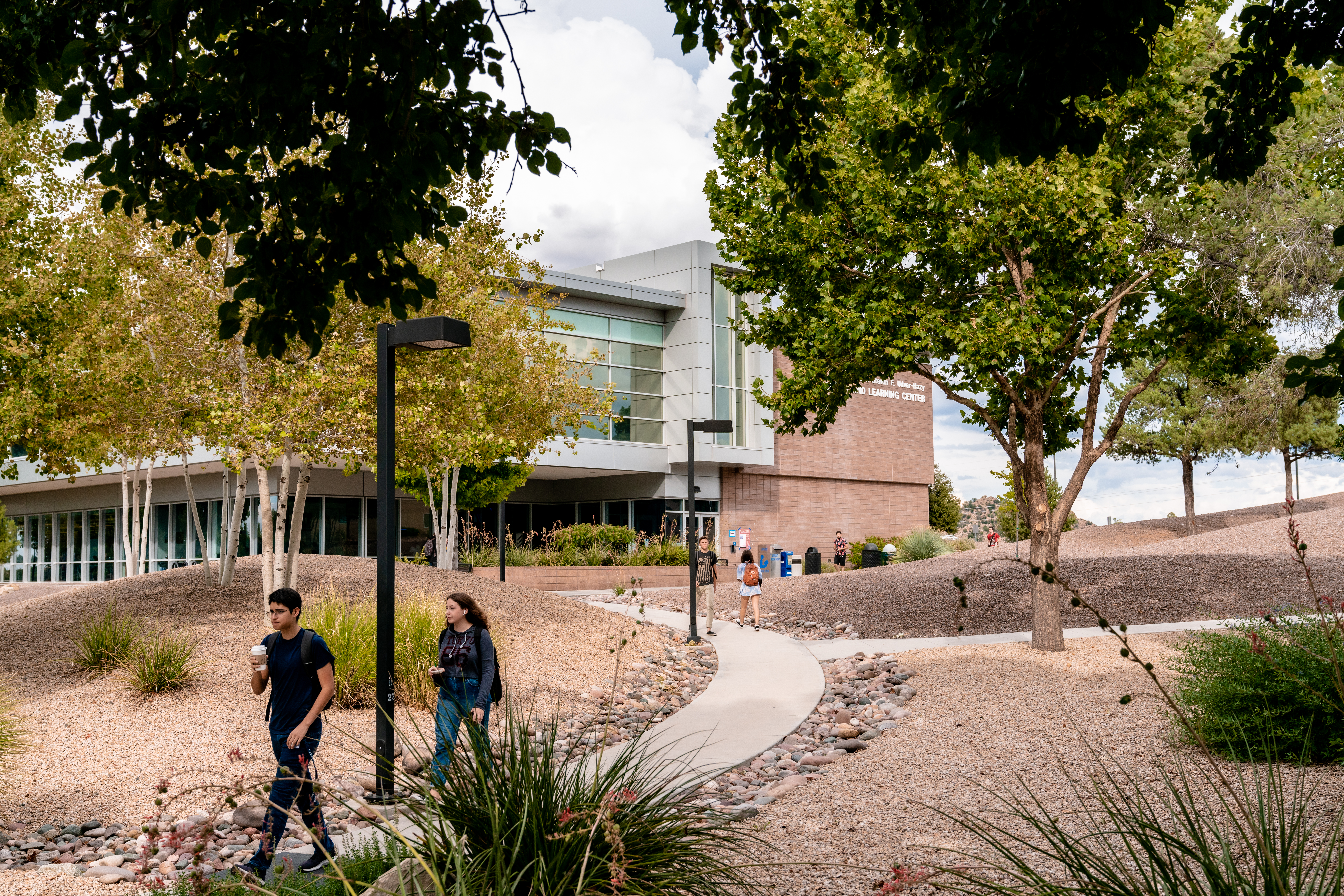 exterior photograph of students walking to and from the Hazy Library building.