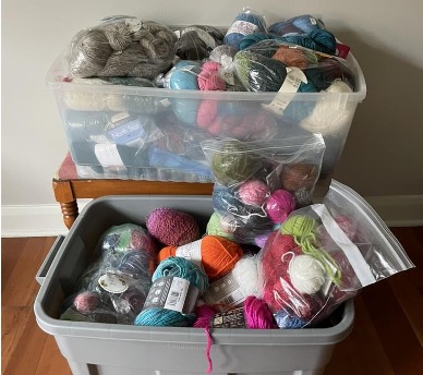 Two plastic tubs filled with bags of yarn.