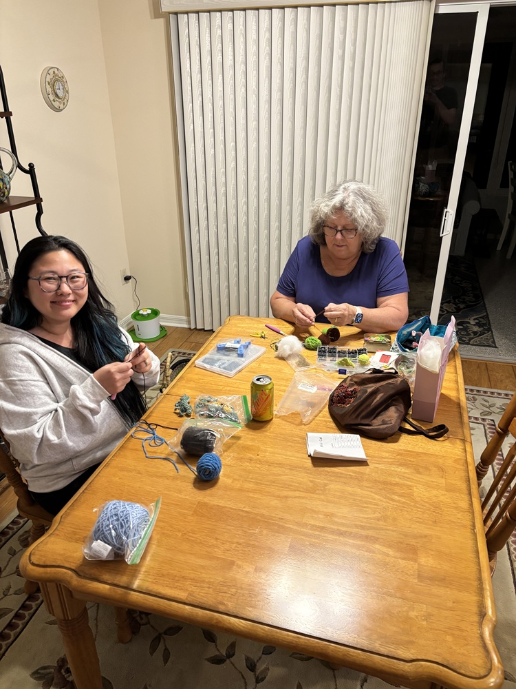 Hannah and her mom, Marcia, crochet together at a kitchen table.