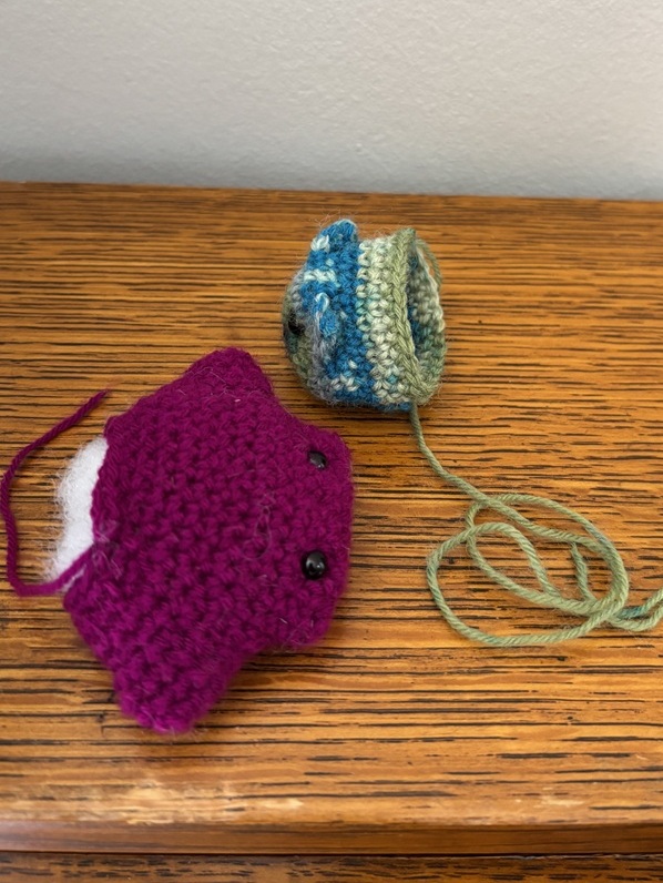 two partially constructed conference creatures with loose ends hanging from them.