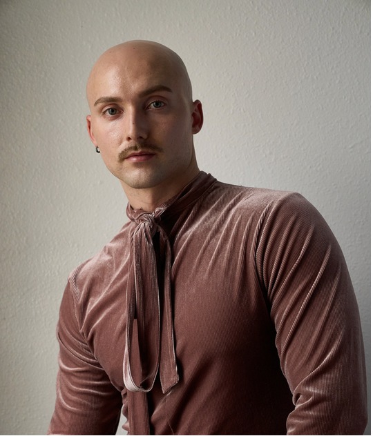 Dr. J. Logan Smilges wearing a dusty rose colored velvet long sleeved shirt