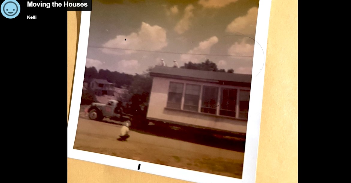 Screenshot at 8:21. Image depicts a Polaroid photo taped to a yellow background. In the photo, a building is on a trailer being pulled by a truck. A person is kneeling in the foreground