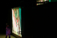 Image of painted eye projected on the side of the CompuObscura model, partially revealing participant leaving the device. Taken by Cal Poly Architecture class students using class-created model and slide projector, Spring 2004.