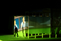 Image of green film frame cast against the side of the CompuObscura with participant leaving the device. Taken by Cal Poly Architecture class students using class-created model and slide projector, Spring 2004.