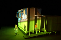 Image of green film frame cast against the side of the CompuObscura with participant leaving the device. Taken by Cal Poly Architecture class students using class-created model and slide projector, Spring 2004.