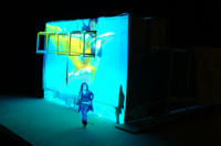 Image of swimming footage cast on the full CompuObscura modeled structure, highlighting participant leaving the device.  Long short. Taken by Cal Poly Architecture class students using class-created model and slide projector, Spring 2004.