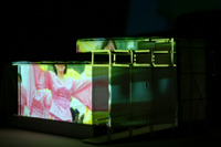 Image of festival parade cast against the side of the CompuObscura. Taken by Cal Poly Architecture class students using class-created model and slide projector, Spring 2004.